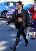 Addison Rae displays her taut midriff in a sports bra, leather jacket and  leggings while leaving