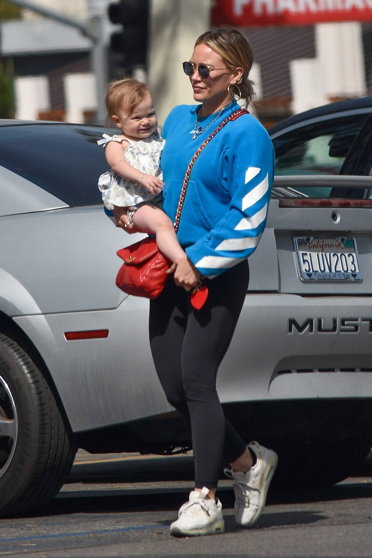 Hilary Duff wears a blue sweatshirt and black leggings during a grocery run  with her daughter