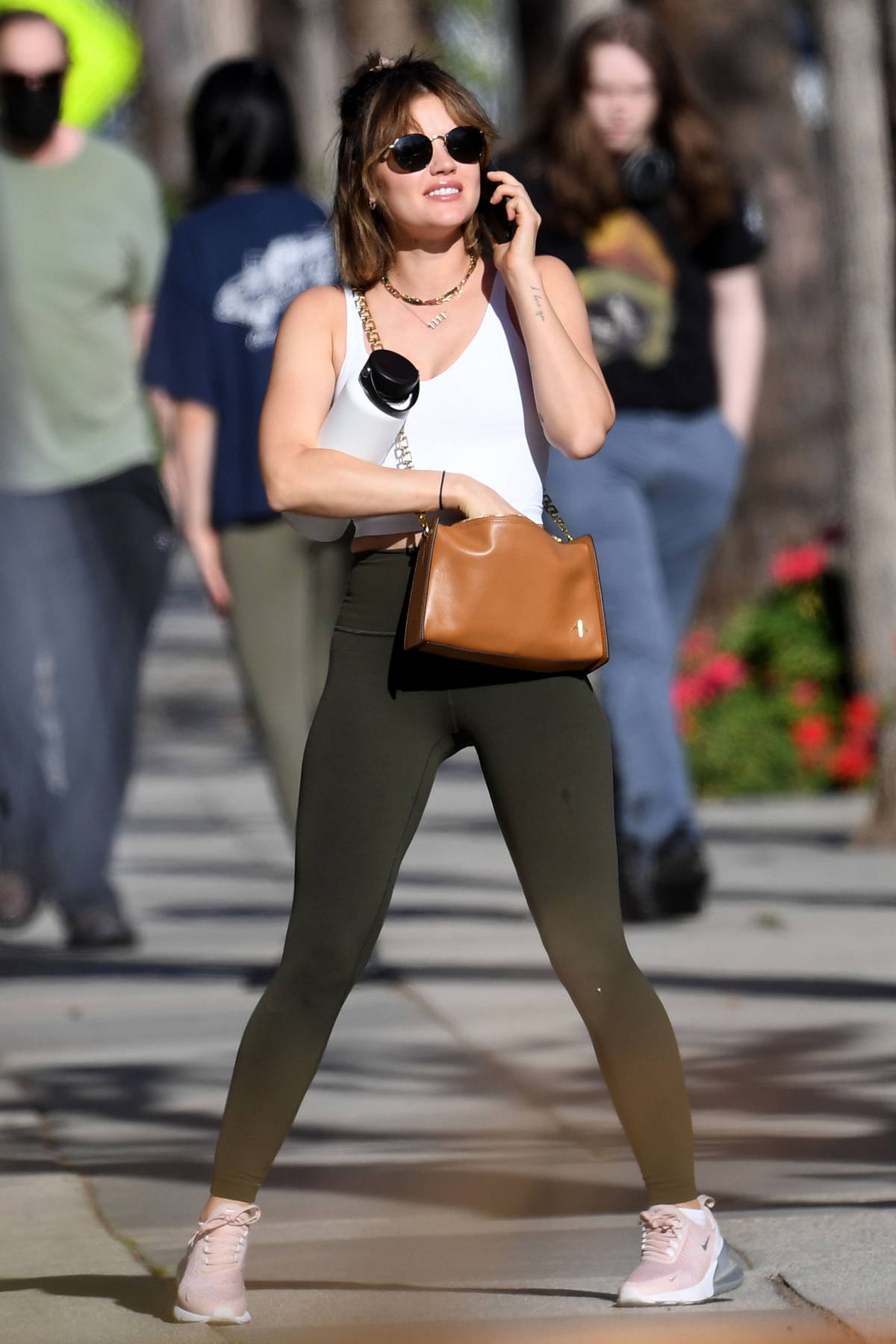 Lucy Hale sports a green tank top and black leggings as she leaves