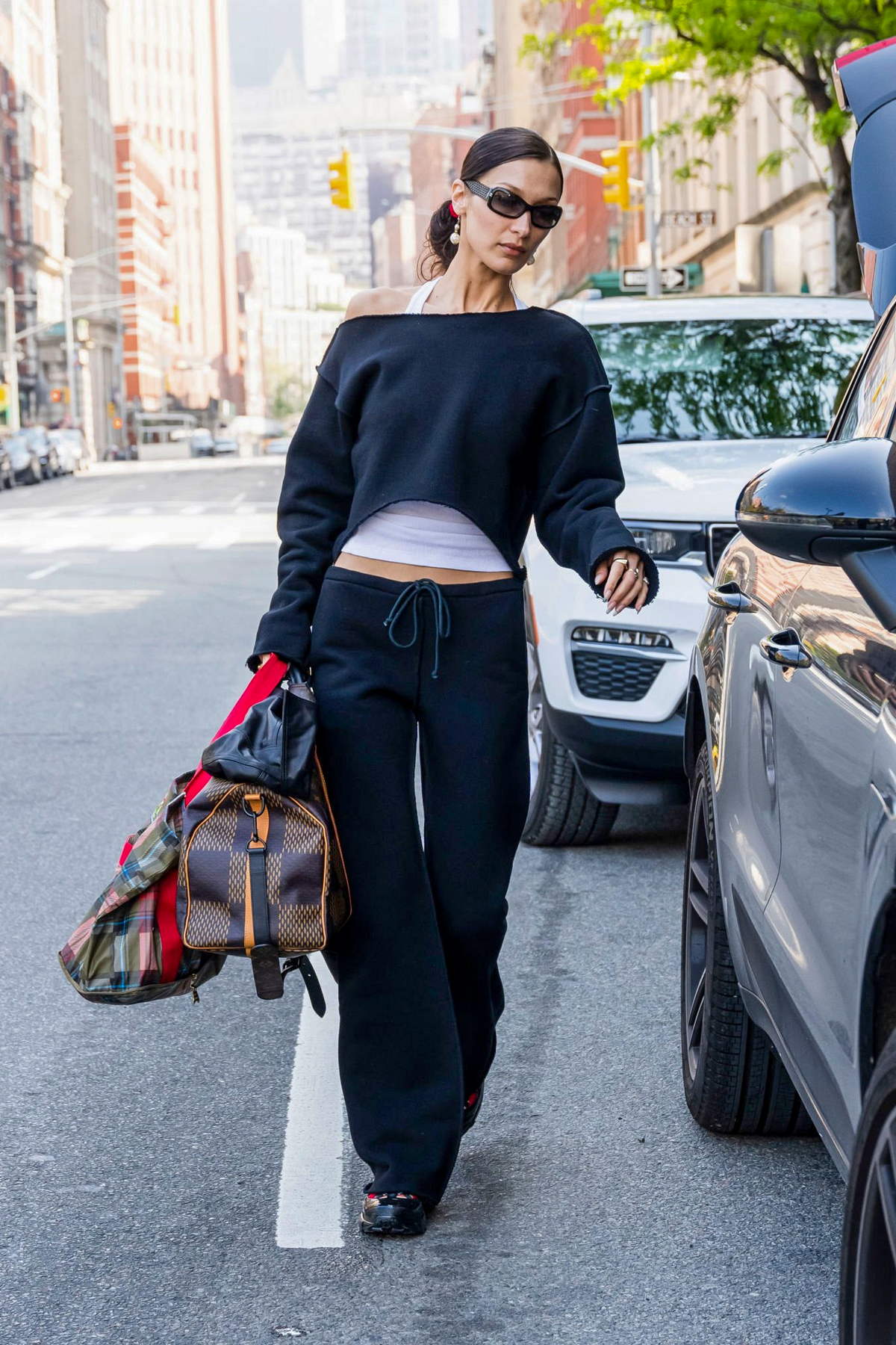 Bella Hadid keeps it chic with a white top and black leggings as she steps  out