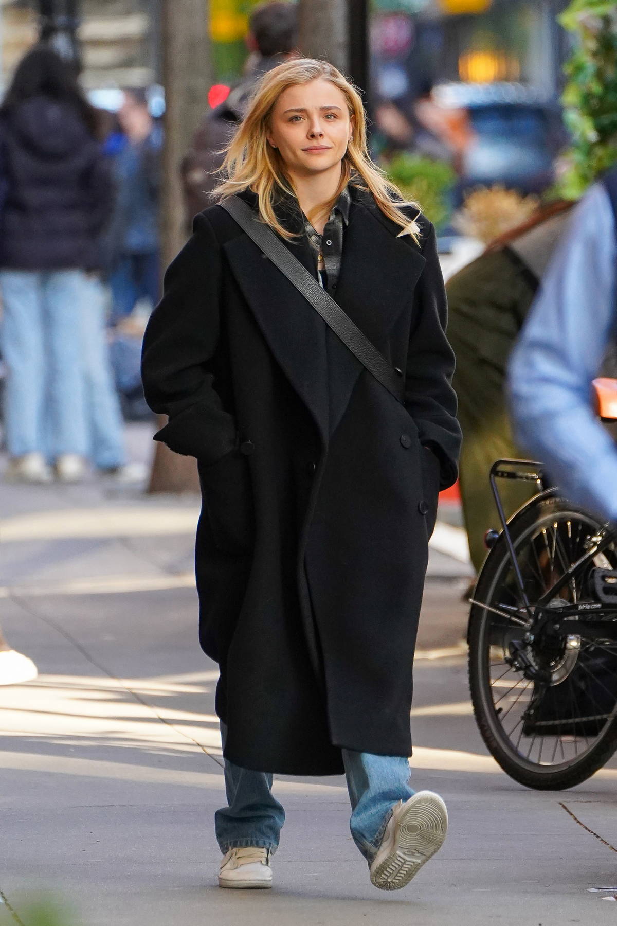 Chloe Grace Moretz wears a black trench coat and jeans while out