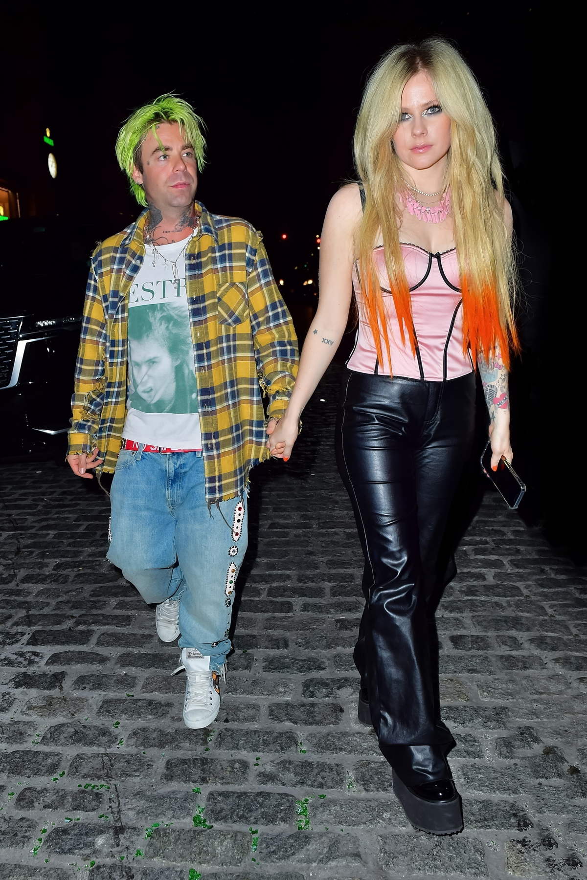Avril Lavigne and boyfriend Mod Sun hold hands as they leave a party in