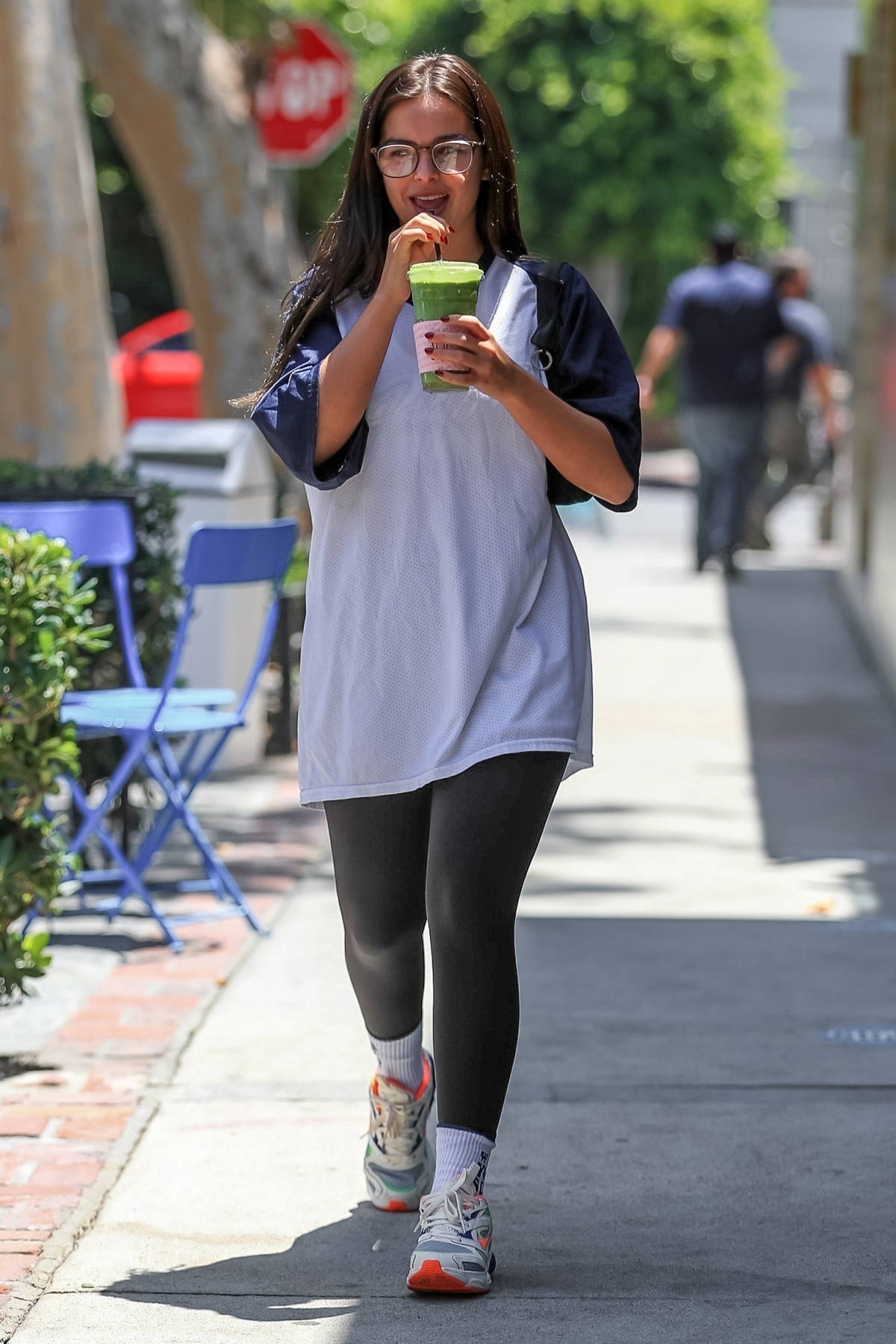 Addison Rae wears an oversized t-shirt and leggings while grabbing