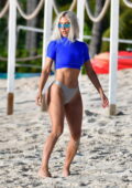 Kim Kardashian shows off her curvy figure in a blue crop top and silver bikini bottoms while enjoying another beach day in Turks and Caicos