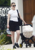 Mia Goth wears a white tee and black shorts while visiting a friend with her newborn in Los Angeles