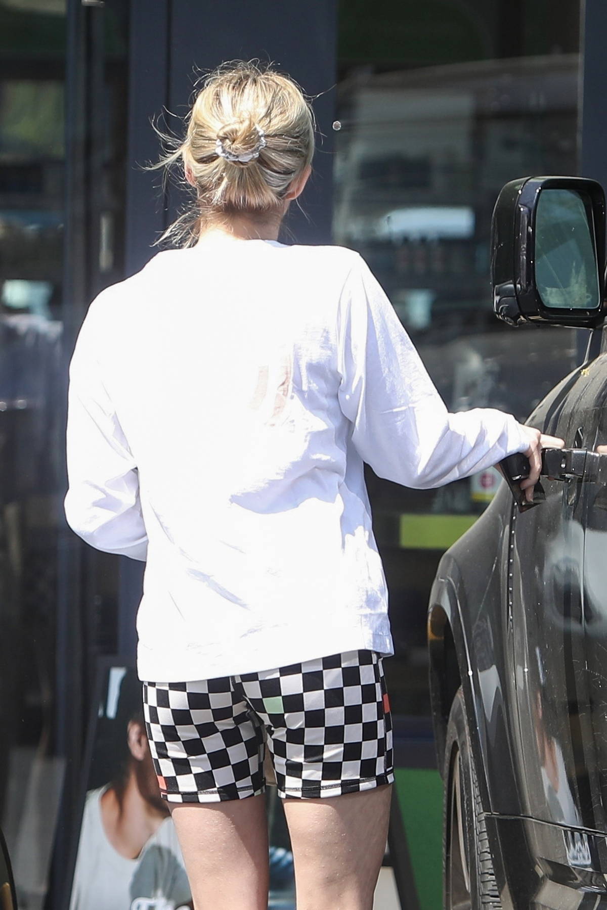 Emma Roberts wears checkered pants and black tee as she steps out