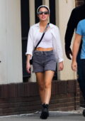 Olivia Rodrigo wears a white shirt over a crop top with denim shorts while stepping out with Daniel Nigro in New York City