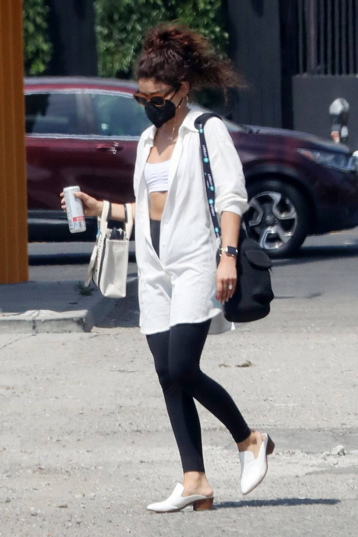 sarah hyland wears a white sports bra with an oversized shirt and