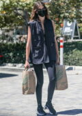 Kaia Gerber wears a black utility vest and black leggings while shopping groceries at Whole Foods in Malibu, California