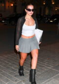Addison Rae shows some legs in a short grey skirt as she arrives back to her hotel after shopping in Paris, France