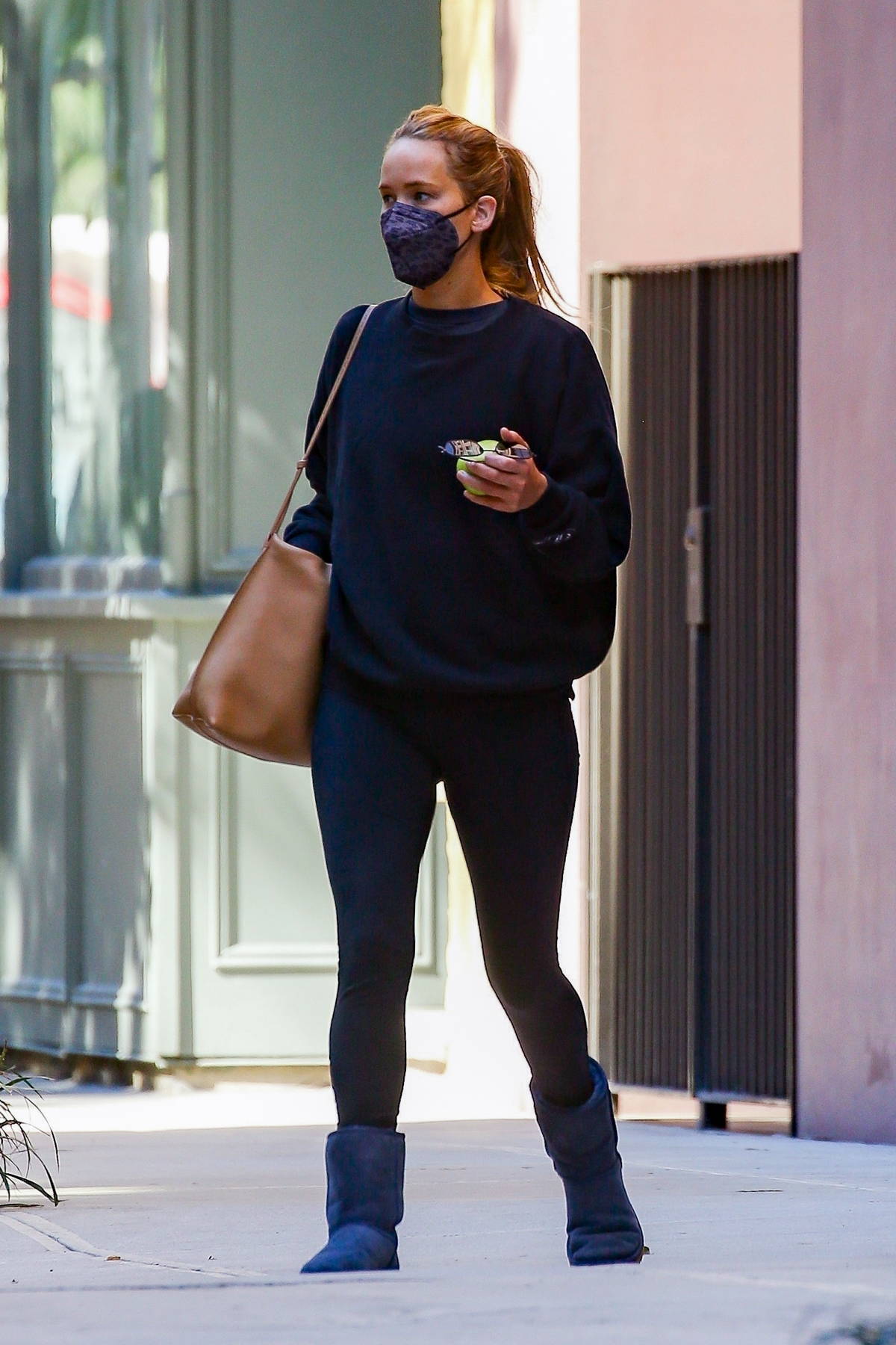 Jennifer Lawrence keeps it cozy in a black sweater paired with matching  leggings and UGGs while