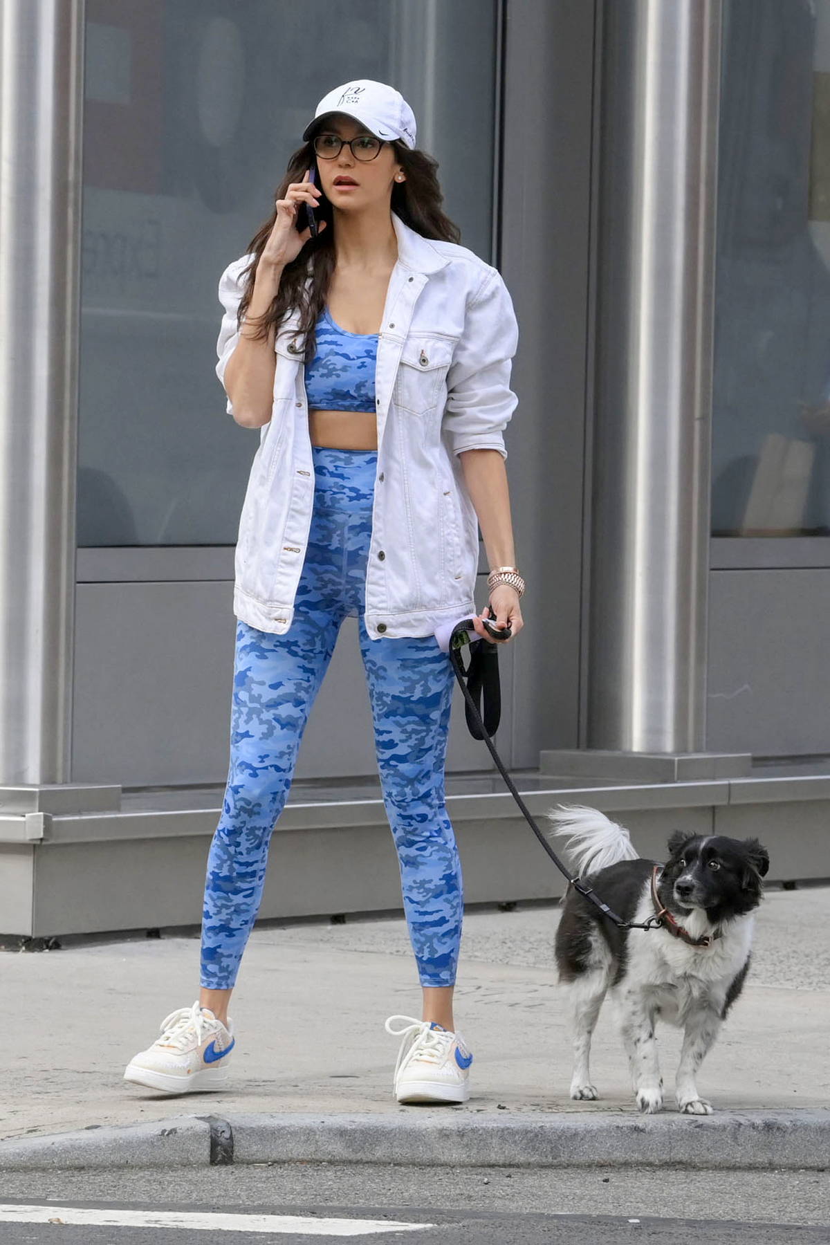 Nina Dobrev rocks patterned blue sports bra and leggings while enjoying a  walk with her dog