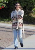 Kendall Jenner wears a knitted blue cardigan with a white top and black  leggings for a