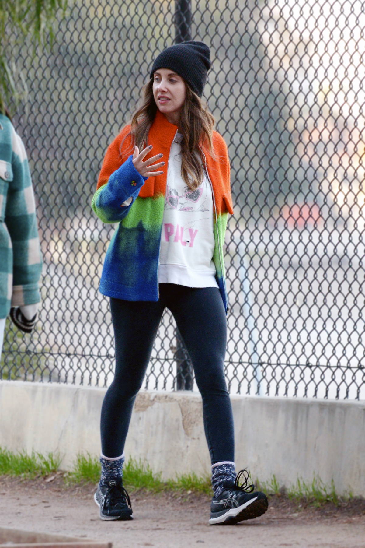 Alison Brie wears a colorful fleece and black leggings as she goes