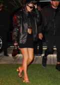 Kylie Jenner displays her toned abs in a cut-out black mini dress and leather jacket while out during Art Basel in Miami, Florida