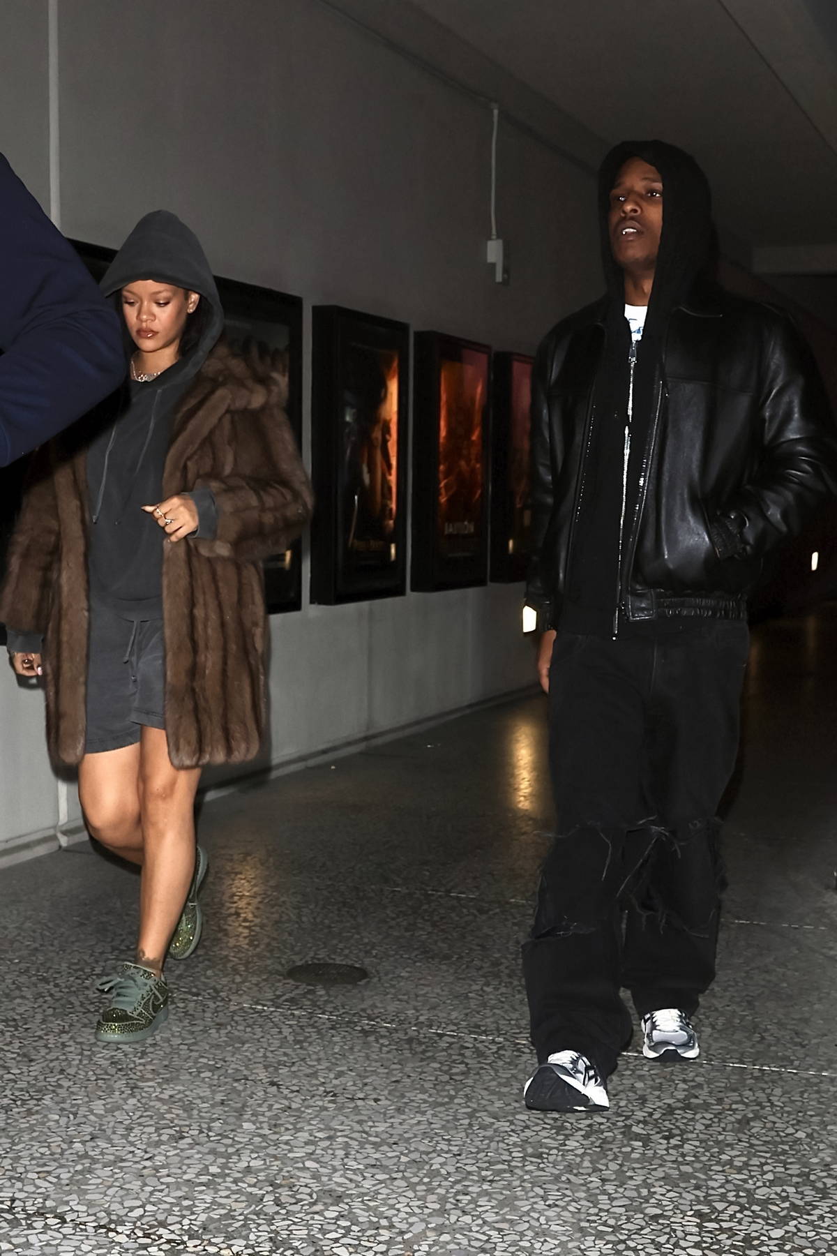 Rihanna wears a dark grey hoodie, shorts and a fur coat during a late night  movie
