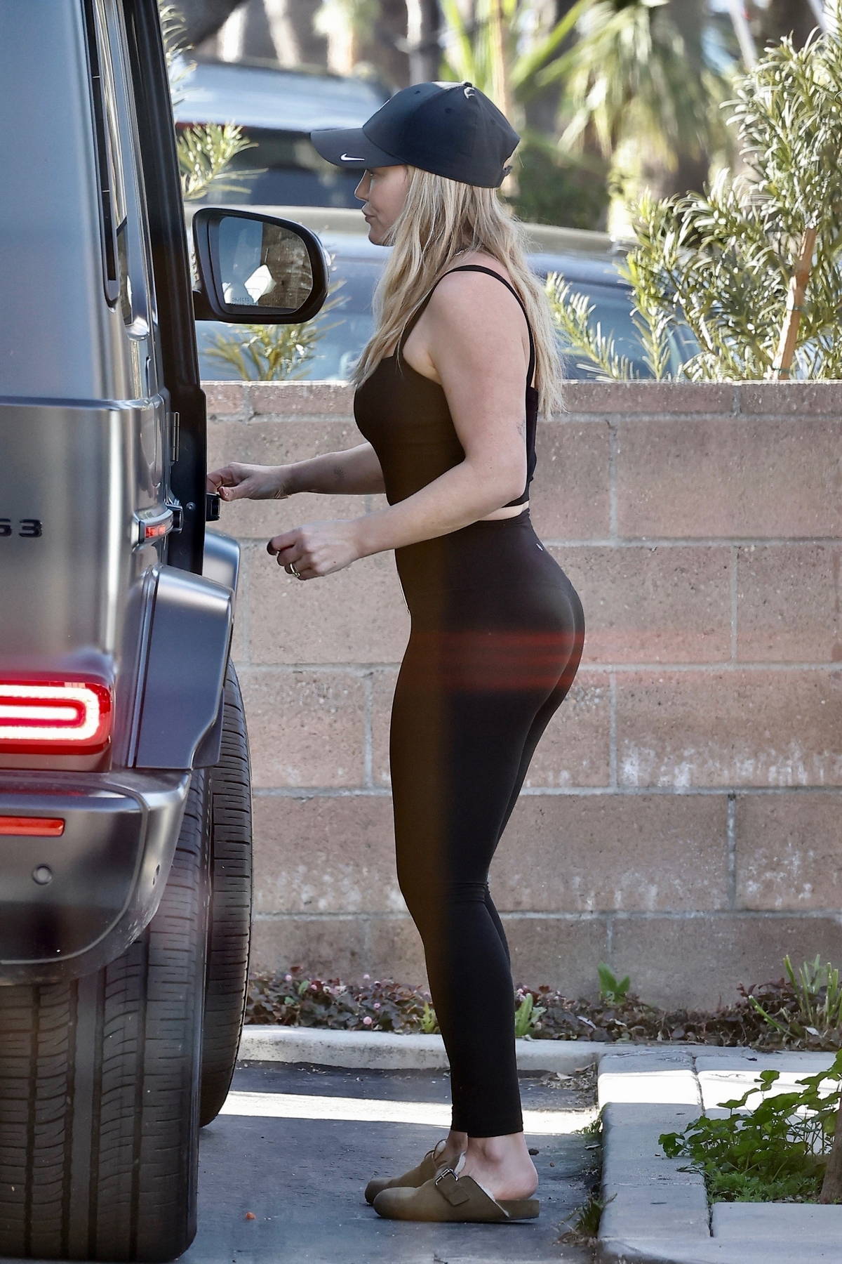 Hilary Duff shows off her curves in a black tank top and leggings