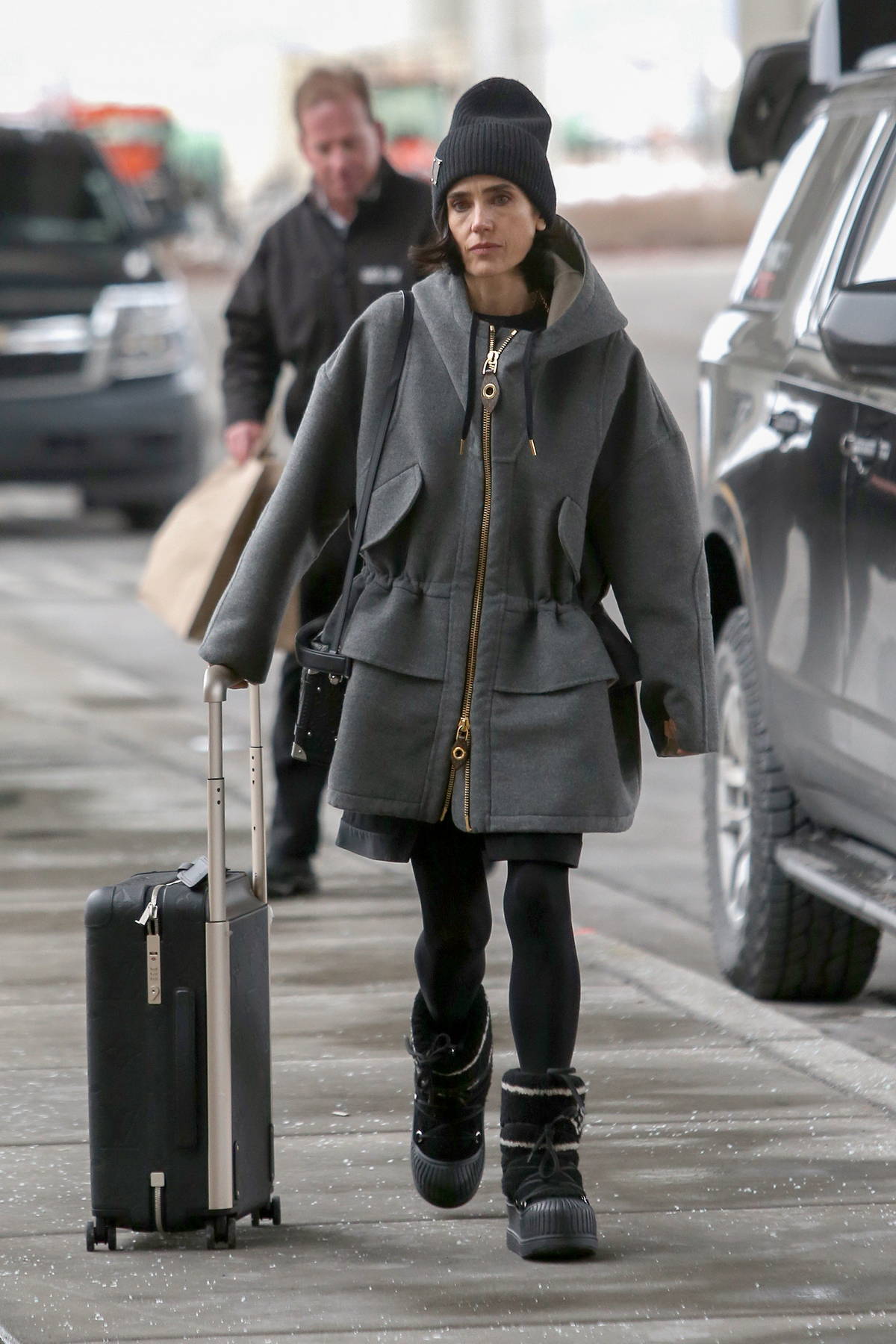 jennifer connelly dons a grey jacket, black tights and louis vuitton moon  boots as she arrives at the airport in salt lake city, utah-230123_6