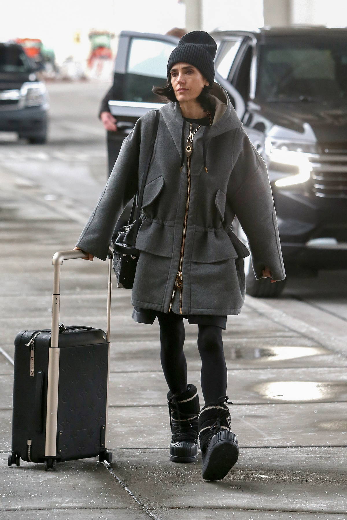 jennifer connelly dons a grey jacket, black tights and louis vuitton moon  boots as she arrives at the airport in salt lake city, utah-230123_2