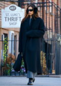 Irina Shayk shows off her winter style in a black overcoat with matching earmuffs while stepping out in New York City