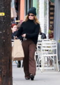 Ashley Tisdale keeps warm in a black sweater and beanie while out to grab lunch to-go in Los Feliz, California