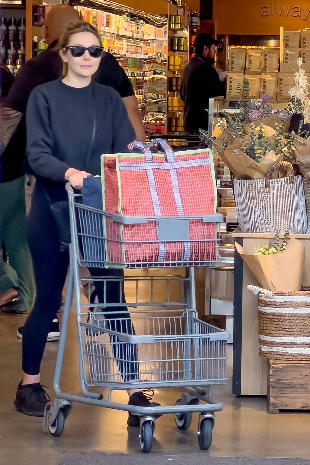 Elizabeth Olsen wears a black sweatshirt and leggings for some grocery shopping at Erewhon Market in Studio City, California