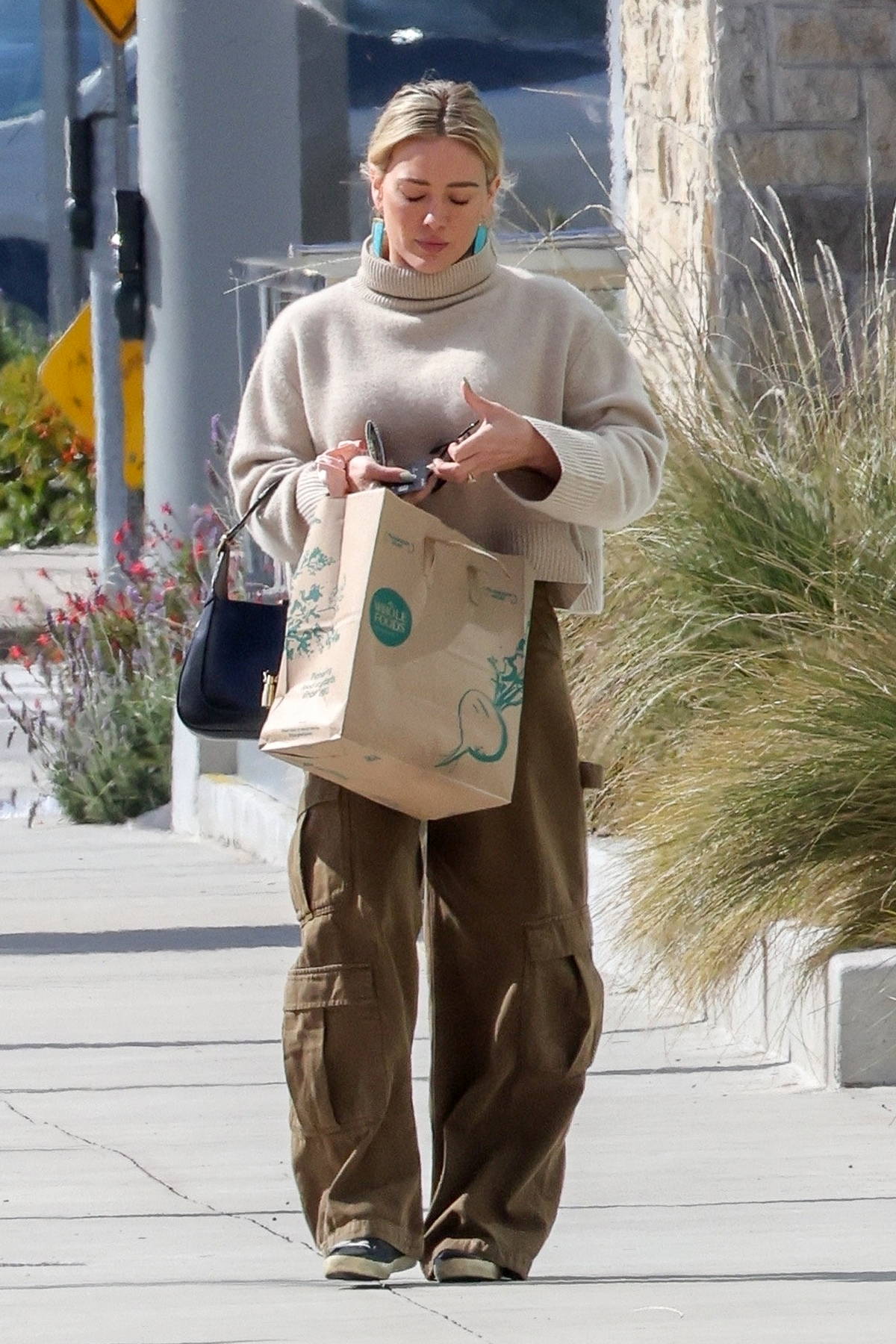 Camila Morrone looks chic in a beige turtleneck sweater and black