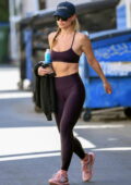 Rita Ora displays her washboard abs in a black sports bra and