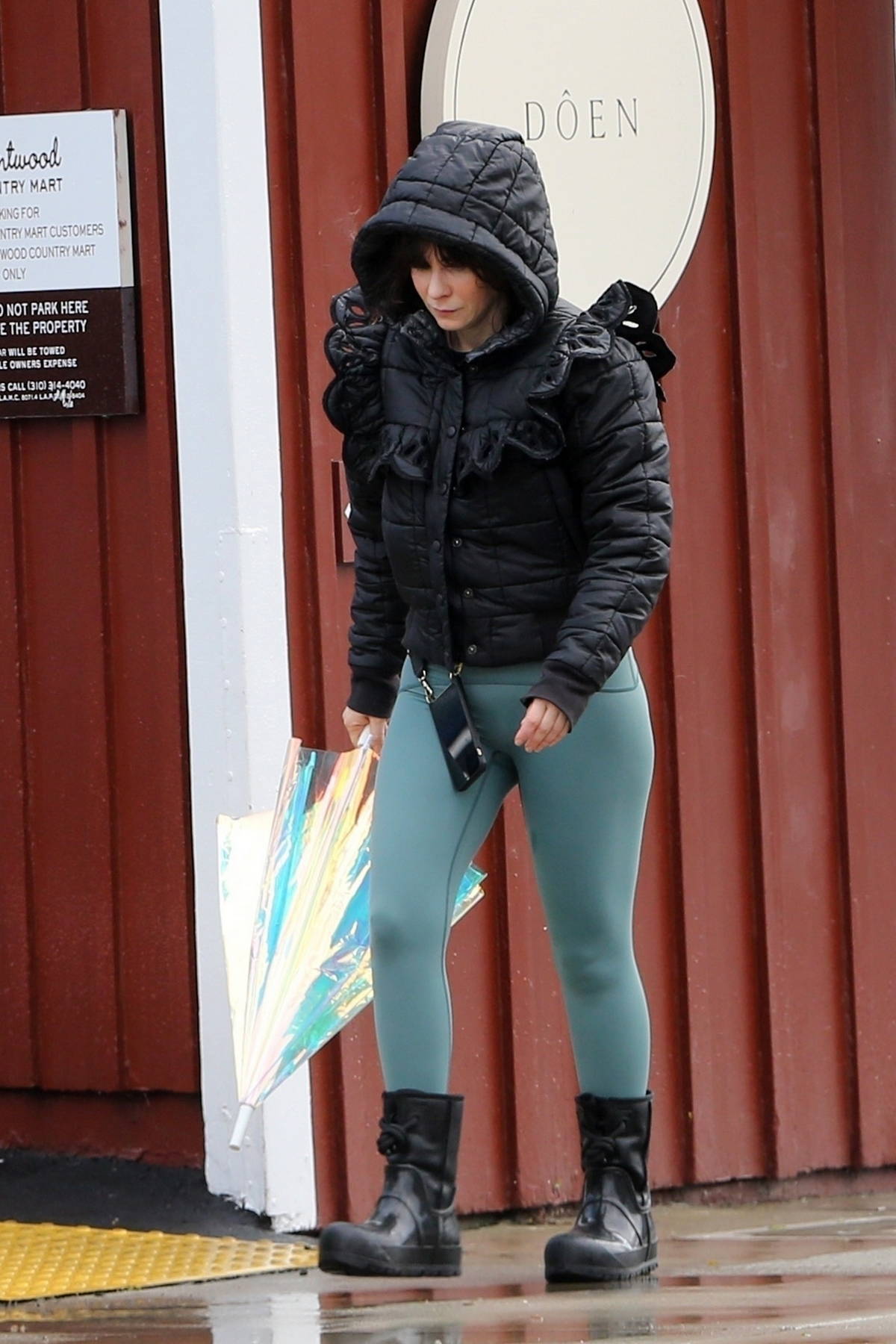 zooey deschanel braves the rain in a hooded puffer jacket and teal leggings  during a coffee run at luxe cafe in brentwood, california-220323_10