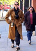 Blake Lively bundles up a brown trench coat and flashes a big smile while out on a stroll with a friend in Tribeca, New York City