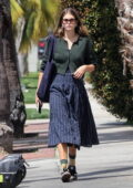 Kaia Gerber wears a pinstriped navy skirt paired with a green cardigan and Adidas sneakers while out in Los Angeles