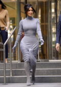 Kim Kardashian displays her famous curves in a grey body-hugging dress while visiting an office building in New York City