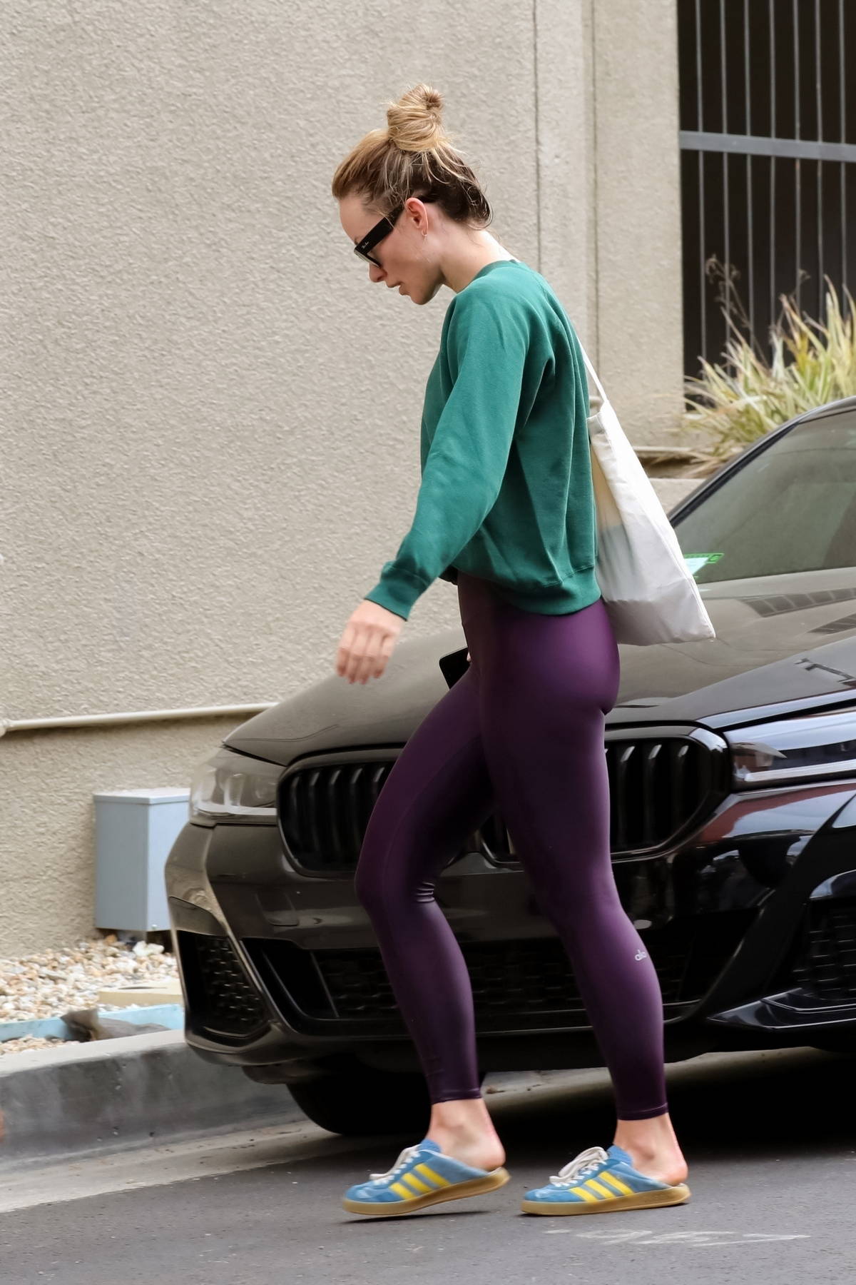 Olivia Wilde sports a green sweatshirt and purple leggings as she