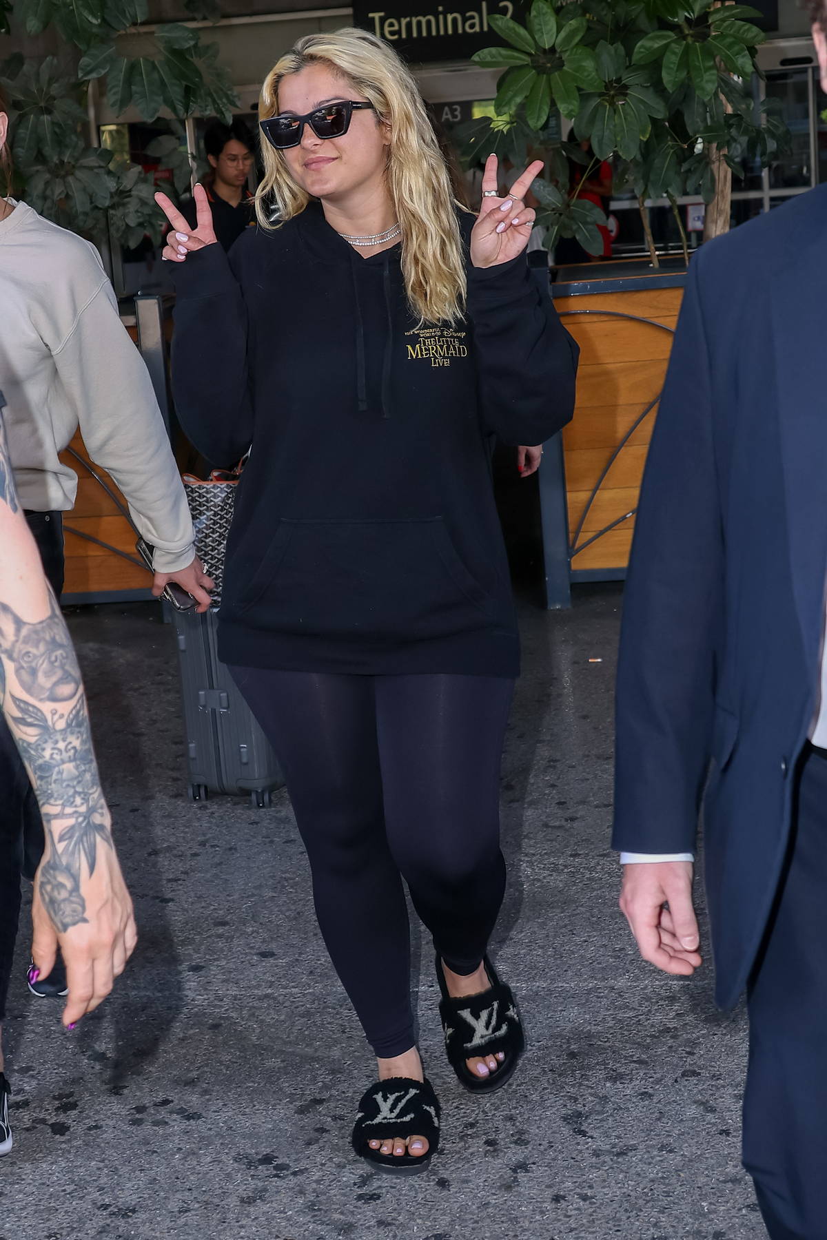 Bebe Rexha wears a black hoodie, leggings and Louis Vuitton slides as she  touches down at