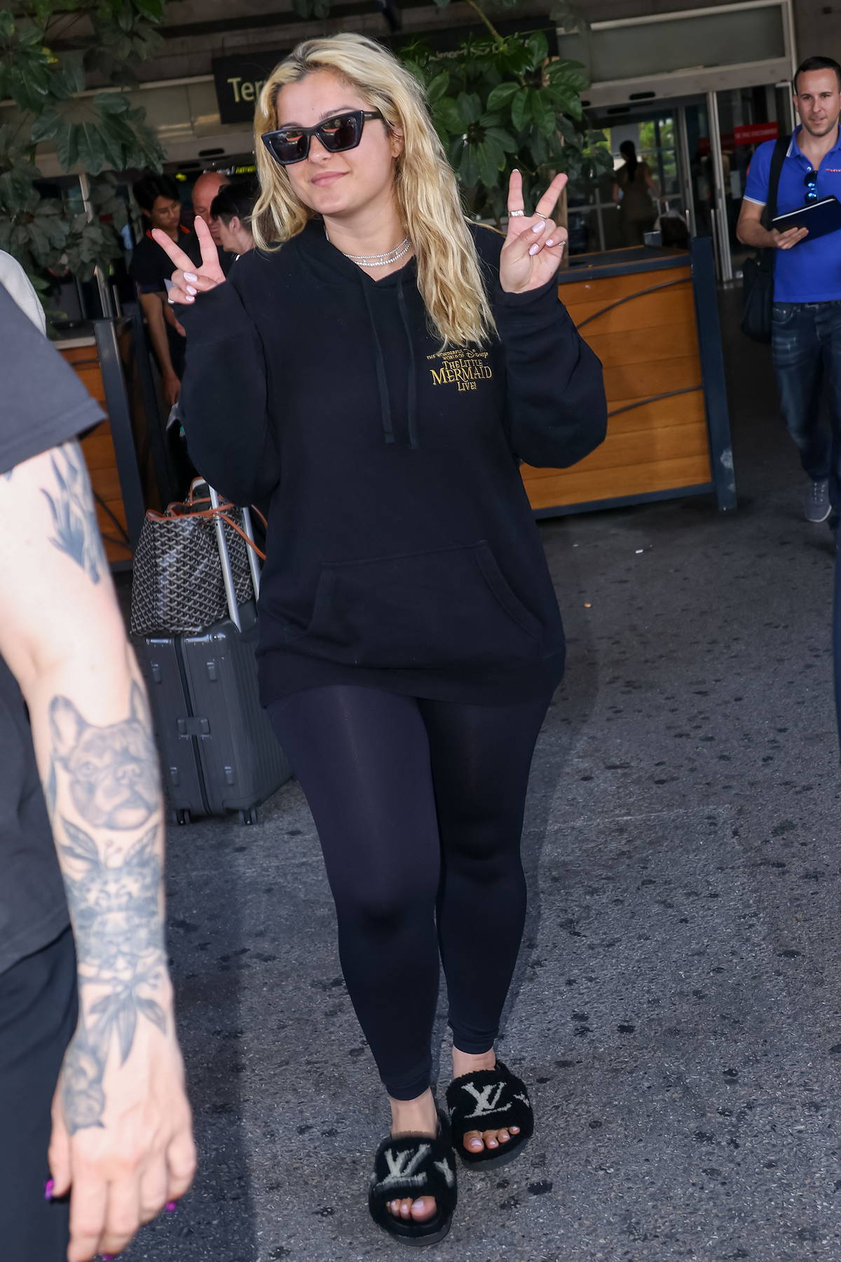 Bebe Rexha wears a black hoodie, leggings and Louis Vuitton slides as she  touches down at