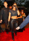 Kim Kardashian flashes her toned abs in a tiny crop top and leather pants while she checks into the Ritz in New York City