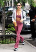 Hailey Bieber dons a set of pink sports bra and flared leggings as she arrives back to her apartment in New York City