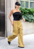 Hailey Bieber rocks a black corset top and mustard yellow trousers while stepping out in New York City