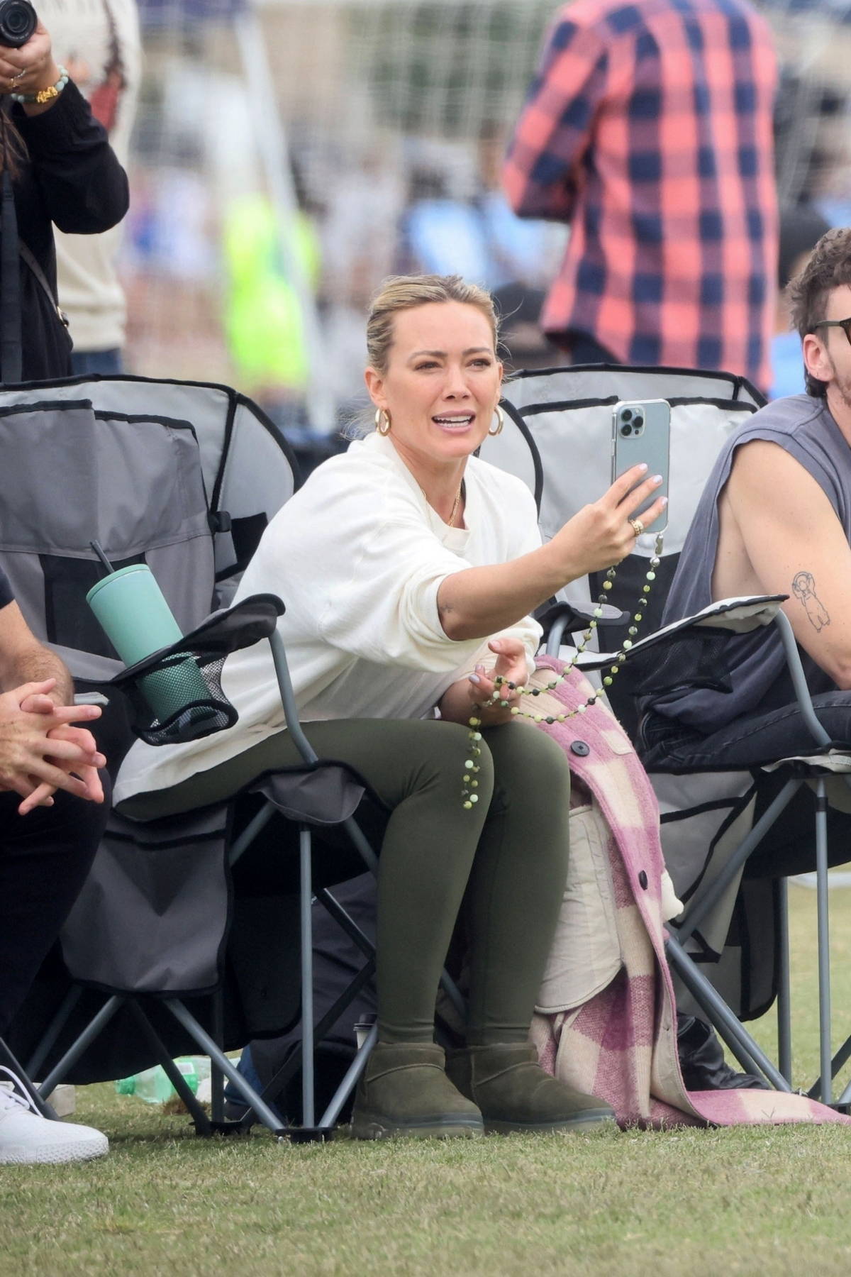 Hilary Duff looks fit in a white tank top and dark brown leggings