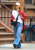 Jennifer Lawrence wears a red shirt with a white tee and blue jeans during a solo outing in New York City