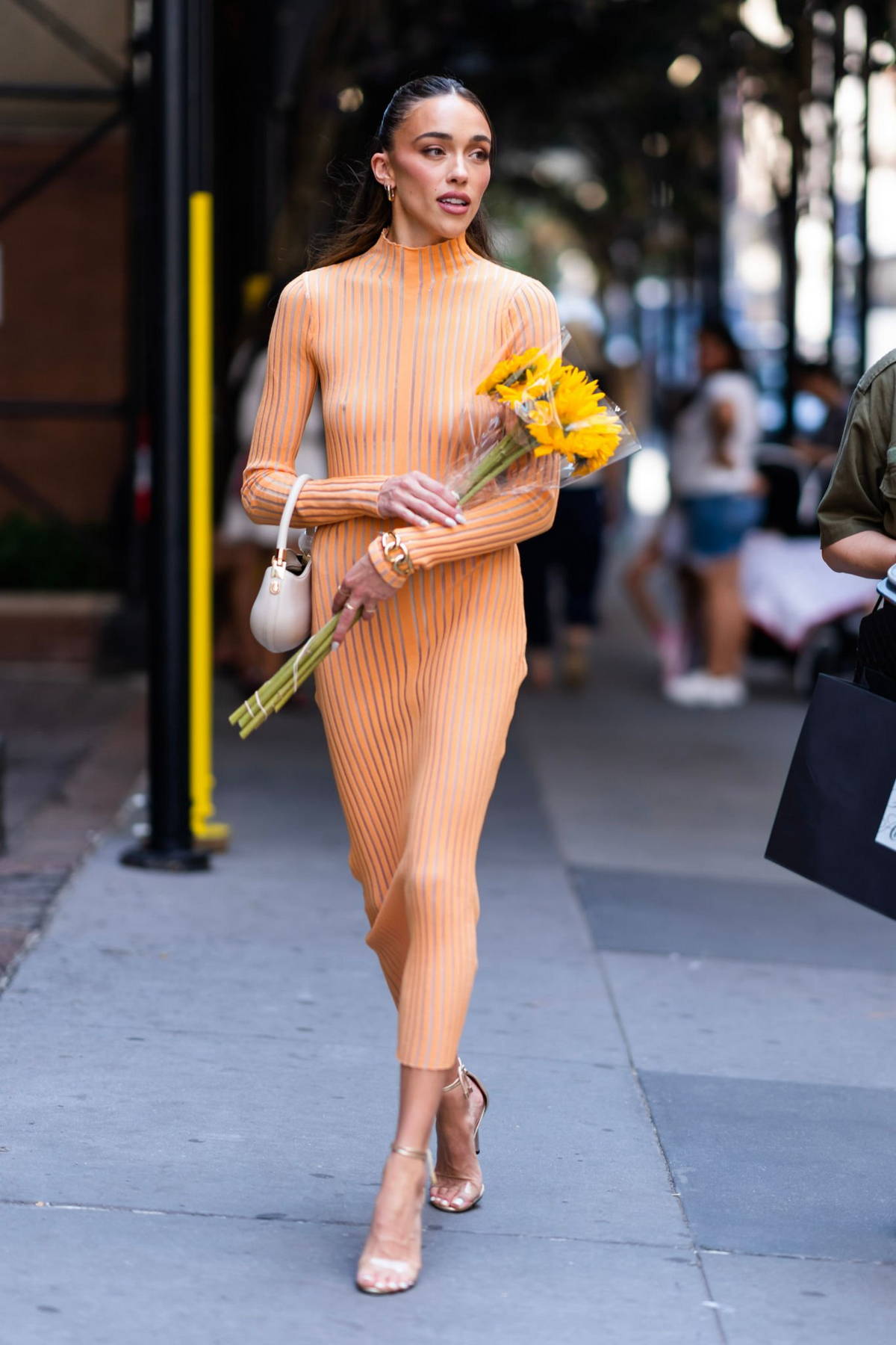 Sophia Culpo looks striking in a semi-sheer orange dress while stepping out  in New York