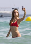 Alessandra Ambrosio looks stunning in a red bikini as she hits the beach while holidaying with her family in Ibiza, Spain