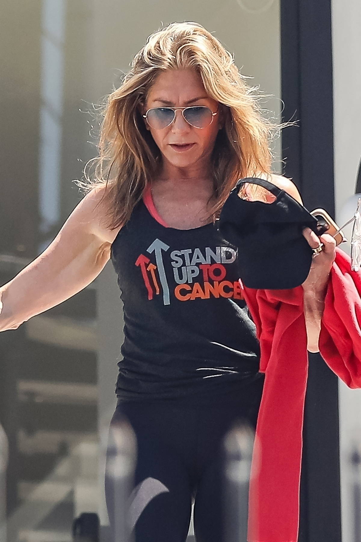 Jennifer Aniston looks fit in a black tank top and leggings while