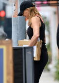 Jennifer Aniston looks fit in a black tank top and leggings while