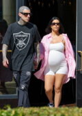 Kourtney Kardashian shows off her baby bump in a white short unitard while enjoying a stroll with Travis Barker in Santa Barbara, California