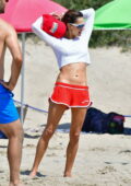 Alessandra Ambrosio flashes her toned abs and legs in red shorts during a beach volleyball game with friends in Santa Monica, California