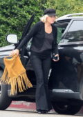 Malin Akerman wears a black cardigan with matching flared denim and beret hat while meeting up with friends in Los Angeles