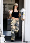 Addison Rae rocks tiger print trousers with a black crop top while making a quick coffee run in Los Angeles