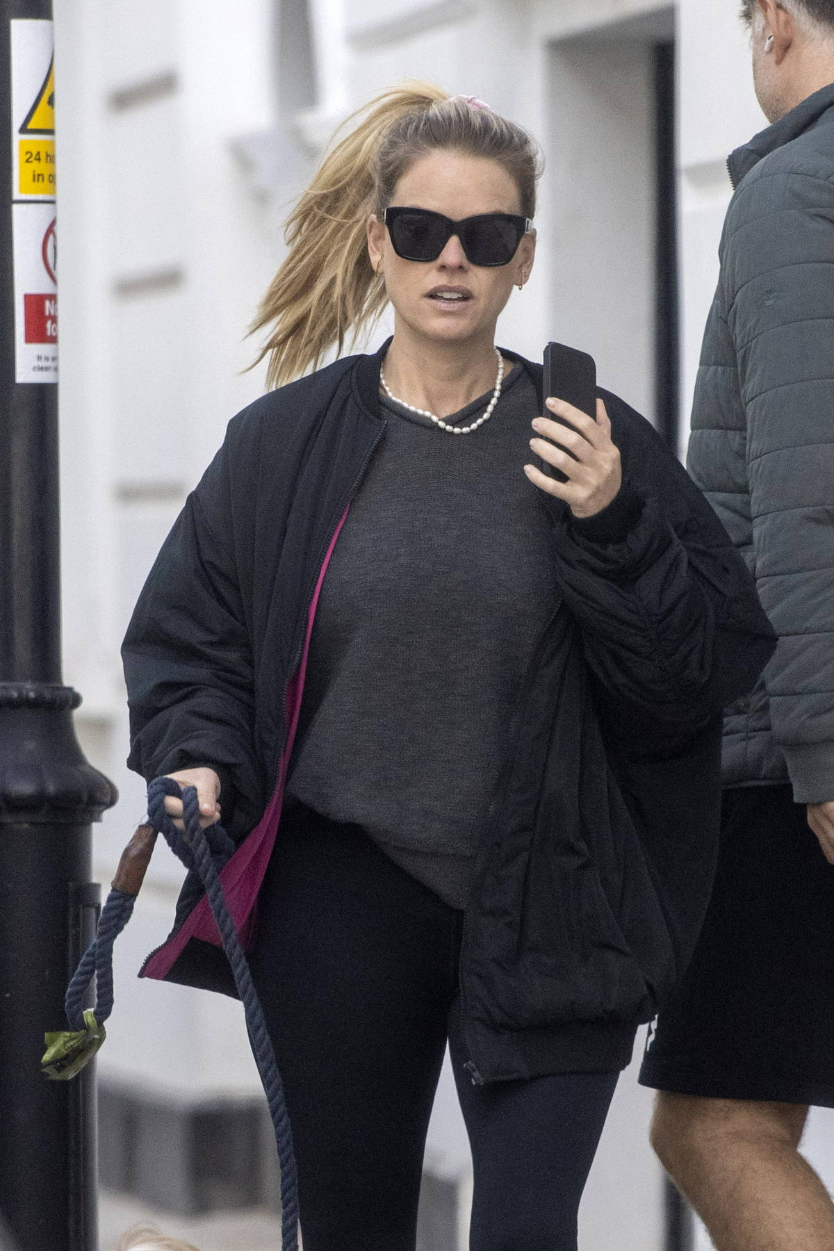 Alice Eve stays cozy in a black jacket, sweater and leggings while