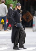 Elizabeth Olsen wears a black trench coat with baggy trousers while out for a stroll with husband Robbie Arnett in New York City